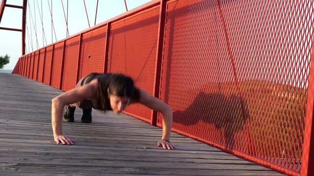 Woman Stretching and Warming Up Before Running on Red Bridge