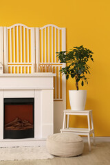 Obraz premium Stylish interior of living room with fireplace and white folding screen