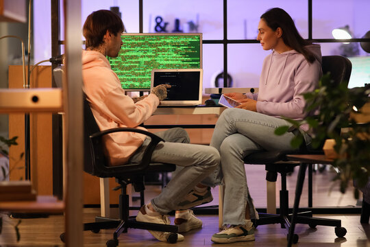 Young programmers working in office at night