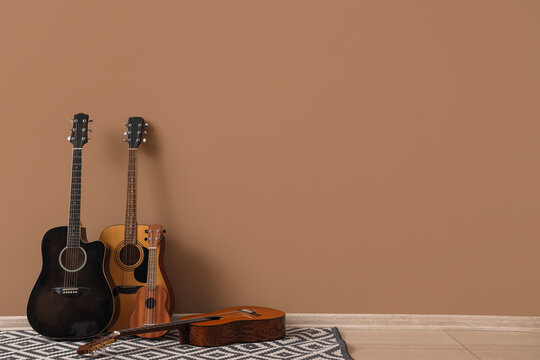 Different guitars near beige wall