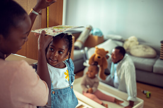 Parents measure daughter's height at home during moving day