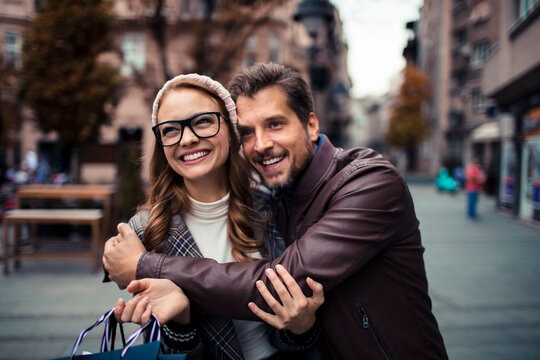 Happy couple shopping on city street