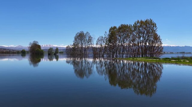 The enchanting reflection of trees and snow-capped mountains in the crystal-clear waters of Elmalı Karag&ouml;l.