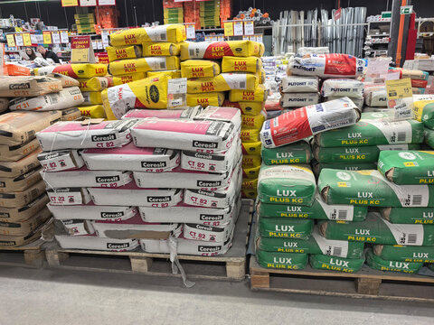 Bulk display of cement bags at a busy hardware store in the afternoon