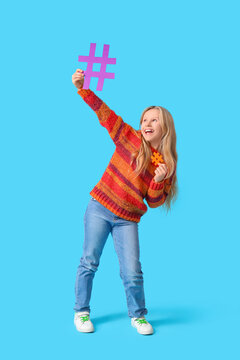 Cute teenage girl with hashtags on blue background