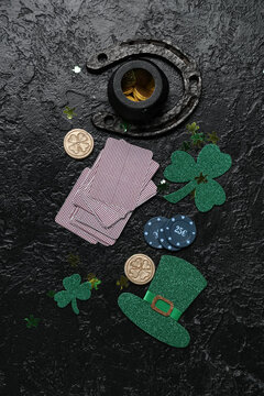 Poker chips, cards and decorations for St. Patrick's Day celebration on black grunge background