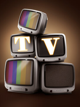 Old TV sets stacked on table. Letters T and V on displays