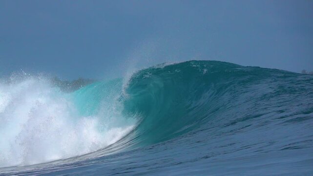 SLOW MOTION: Turquoise barrel folds over with explosive power on a reef in the Mentawai Islands. Empty wave, misty lip and smooth ocean surface capture a dramatic moment of raw Indian Ocean perfection
