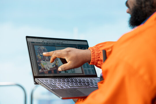 Close up of monitoring operations software interface on laptop used by offshore rig worker on oil platform deck. Drilling rig expert reviewing energy operations using notebook application