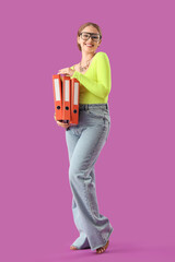 Naklejka premium Young woman with document folders on purple background