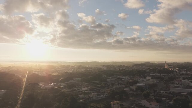 aerial drone lateral movement from railway to church during sunrise over suburban city