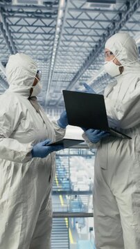 Vertical video Engineers monitoring microelectronics smart factory workflow using EDA software on display. Professionals use simulation application tracking microchip production circuit layout defects