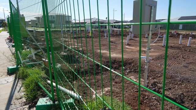 Active construction site in Tarneit, a growing outer suburb of Melbourne, Australia,&nbsp;Behind the perimeter fencing, bare disturbed soil, PVC pipes, conduits, ongoing underground services installation