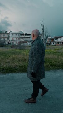 Elderly man walking in the park on a gloomy cloudy day in winter