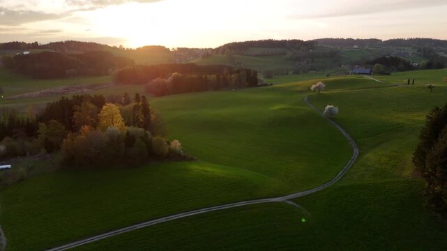 Aerial View of Idyllic Rural Countryside with Green Hills and Country Road at Golden Hour, Lake Constance Region, Central Europe