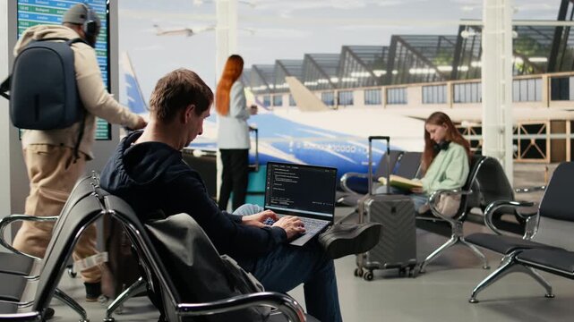 Digital nomad man programming on laptop in international airport, writing code and developing software systems while waiting for flight departure. IT engineer with location independent lifestyle.