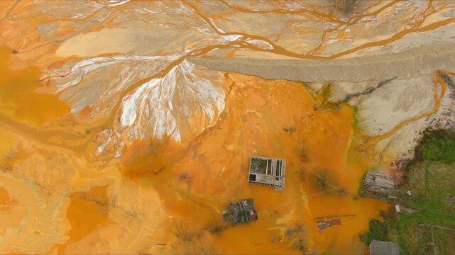 Aerial view of the flooded village of Geamana showing abandoned houses submerged in toxic orange cyanide-laced water from the Rosia Poieni mine Geamana, Alba County, Romania.