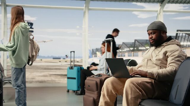 Digital nomad stretching muscles of lower back and neck near the gate, waiting for international flight. Flexible remote online work with global mobility and virtual office in airport terminal.
