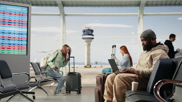 Worried digital nomad frustrated about all flights cancellation, postponed departures creating chaos. Black professional stranded in the airport, stressful impact of airline shutdown.