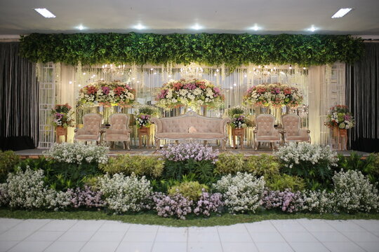 wElegant wedding decorated with white flowers, lush greenery, and soft drapery, leading to a romantic arch under warm lighting.edding decoration