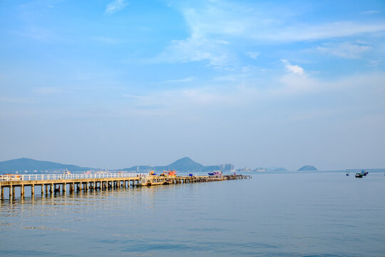 Tranquil pier sunset coastal location scenic photograph calm waters distant islands nature's serenity
