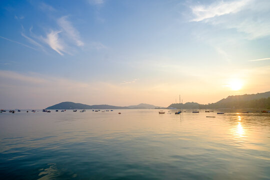 Sunrise reflection over tranquil waters with fishing boats coastal region landscape photography serene environment