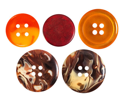 Isolated photo of orange and stone colored cloth buttons on white backdrop.