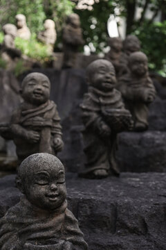 Stone Jizo statues in Kyoto temple garden with shallow depth of field