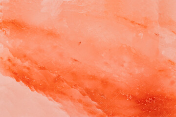 Fototapeta premium Texture of orange stone showing layers with shades of pink and light red in natural light