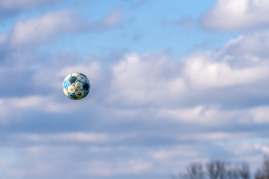 Soccer Ball Floating in Cloudy Blue Sky with Copy Space