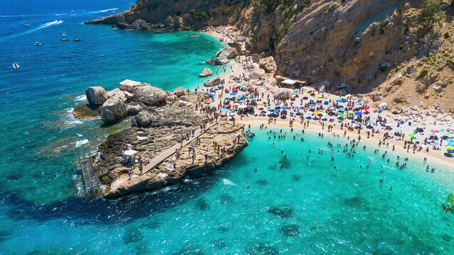 Aerial view of Cala Mariolu beach with its wooden pier and turquoise water, Gulf of Orosei, Baunei, Sardinia, Italy