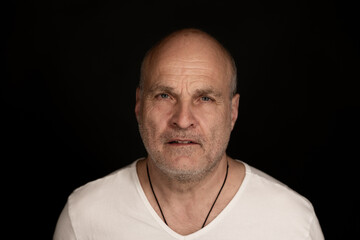 Obraz premium Middle aged man looking directly at camera with intense emotion against a black background