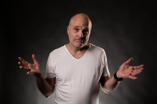 Confused bald man shrugging shoulders with open hands, showing doubt and ignorance