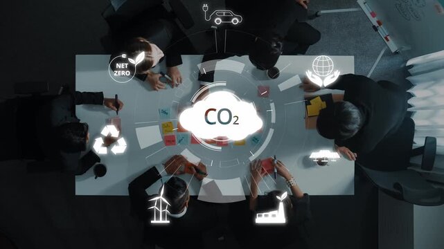 A diverse team of professionals collaborates in a modern office, discussing sustainable practices and strategies for achieving carbon neutrality in business initiatives. Raster