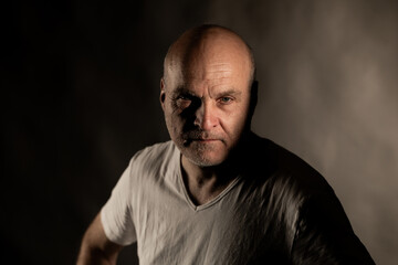 Fototapeta premium Mature bald man portraying a serious and intense expression in studio portrait