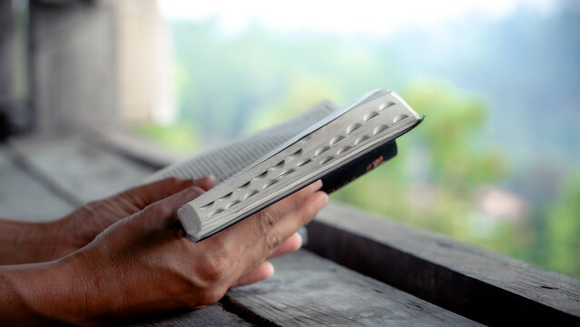 Close up hands of a man reading the Bible Spiritual concepts by studying the Holy Scriptures together, devotional concept