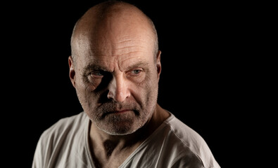 Fototapeta premium Older bald man with stubble and wrinkles showing a serious and intense expression