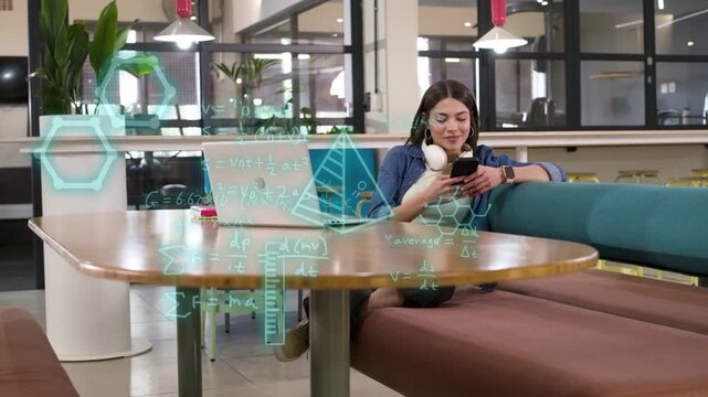 Woman tapping phone in workspace, generating teal holograms and graphs over laptop for education
