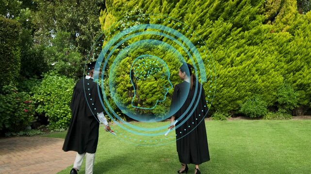 Two grads walking inward after second entering left, gesturing with blue HUD celebrating graduation