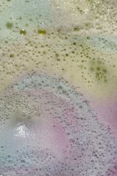 Foam from bath bombs creates colorful spacy background plate