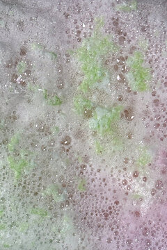 Foam from bath bombs creates colorful spacy background plate