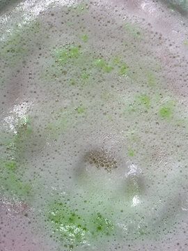 Foamy soap from bath bombs creates colorful spacy background plate