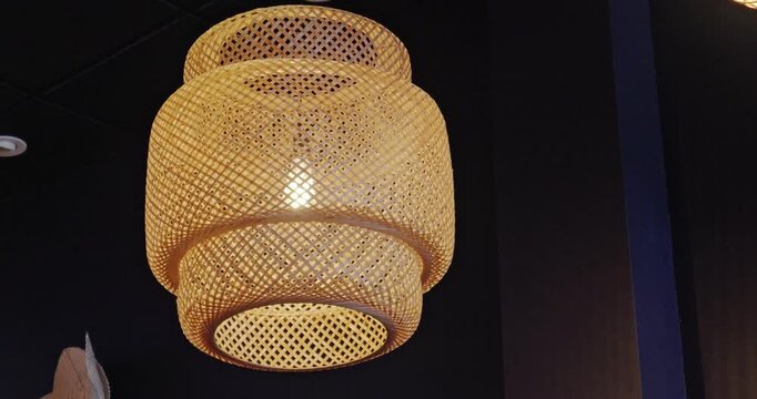Modern woven bamboo pendant light with warm glowing bulb