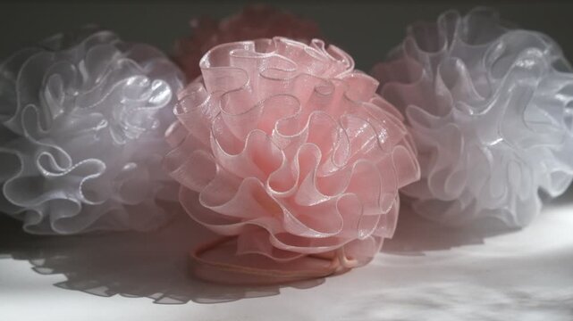 Interlacing flounces of the finest pink silk pleats of textured fabric like a rose flower, light pink fabric bows for decoration stage costume