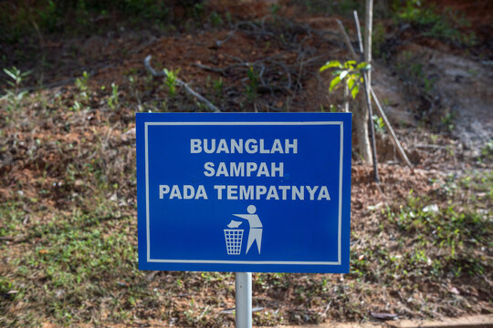 Indonesian trash disposal sign in the park, littering warning signage.