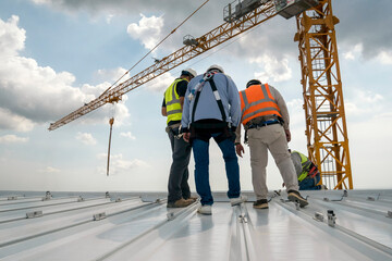 Construction engineer wear safety uniform inspection metal roofing work for roof industrial concept with copy space © Rassarin