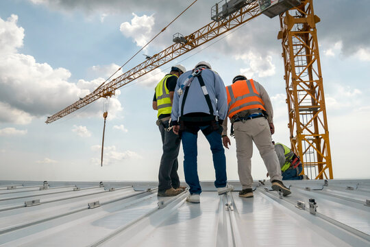 Construction engineer wear safety uniform inspection metal roofing work for roof industrial concept with copy space