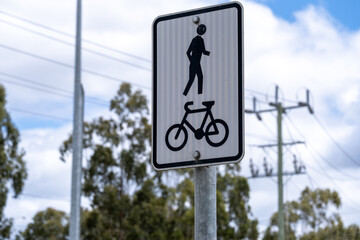 A shared pedestrian and bicycle path sign on a metal post in suburban Melbourne,...
