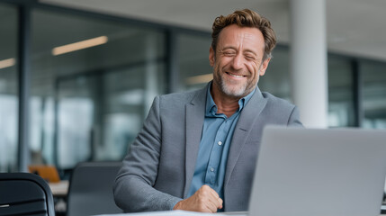 Obraz premium Contented Businessman: A mature businessman beams with genuine contentment while working on a laptop, embodying confidence and professional satisfaction.