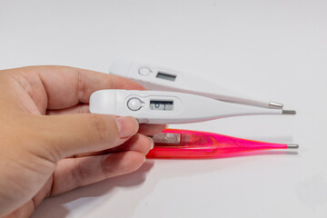 Obraz premium Hand holding a digital clinical thermometer for body temperature measurement.